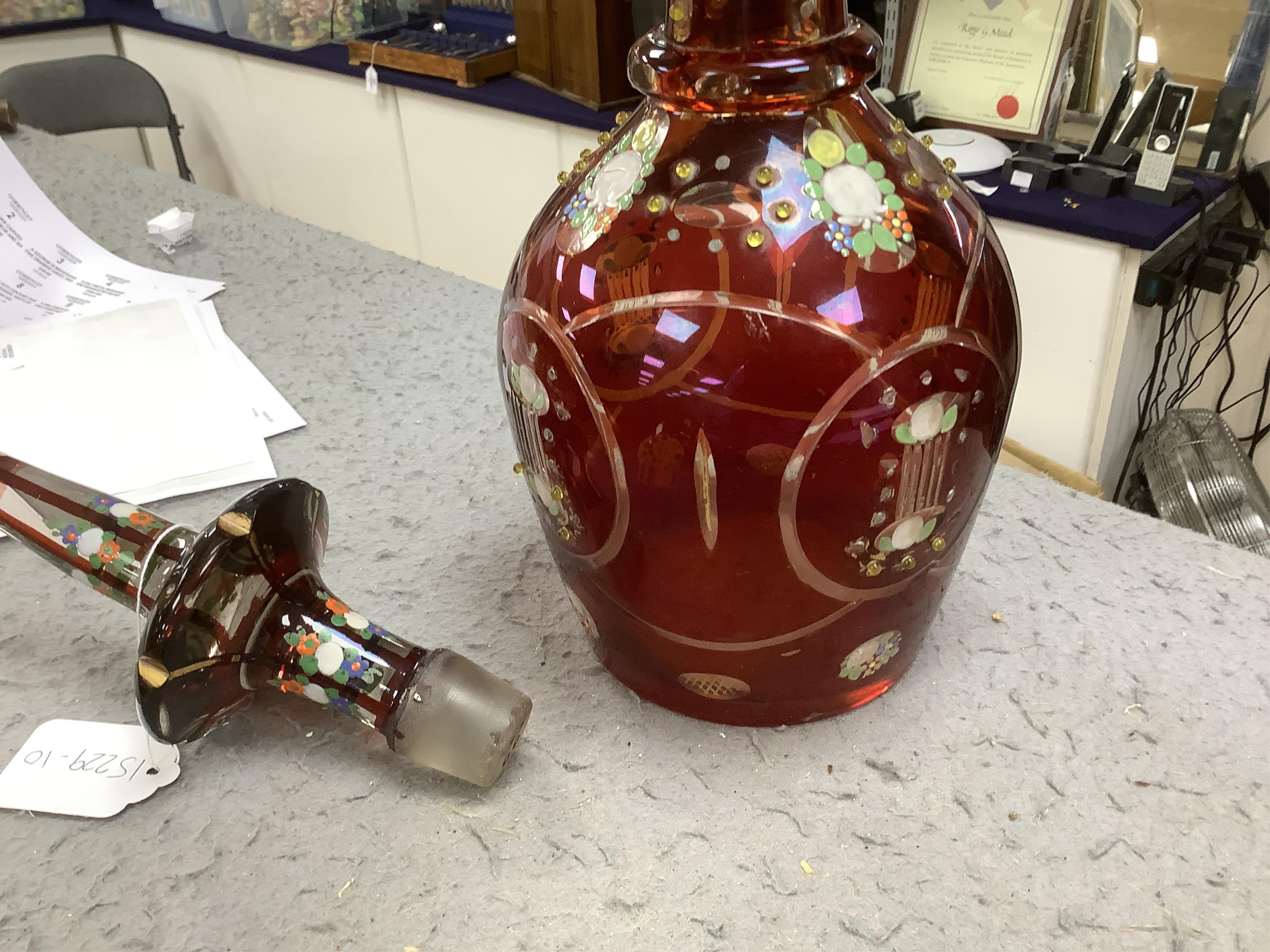 An early 20th century Bohemian overlaid and painted ruby glass decanter, 51cm. Condition - fair